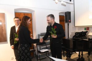 Młoda dziewczyna wręcza artystom róże