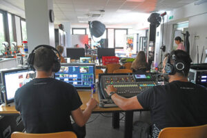 Studio nagraniowe. Na pierwszym planie widoczni tyłem pracownicy firmy SZOK, która realizowała nagranie. 