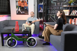 Studio nagraniowe. Na dwóch szarych kanapach siedzą: z lewej Bartłomiej Krystyński, z prawej - widoczna z profilu - Kornelia Sowa