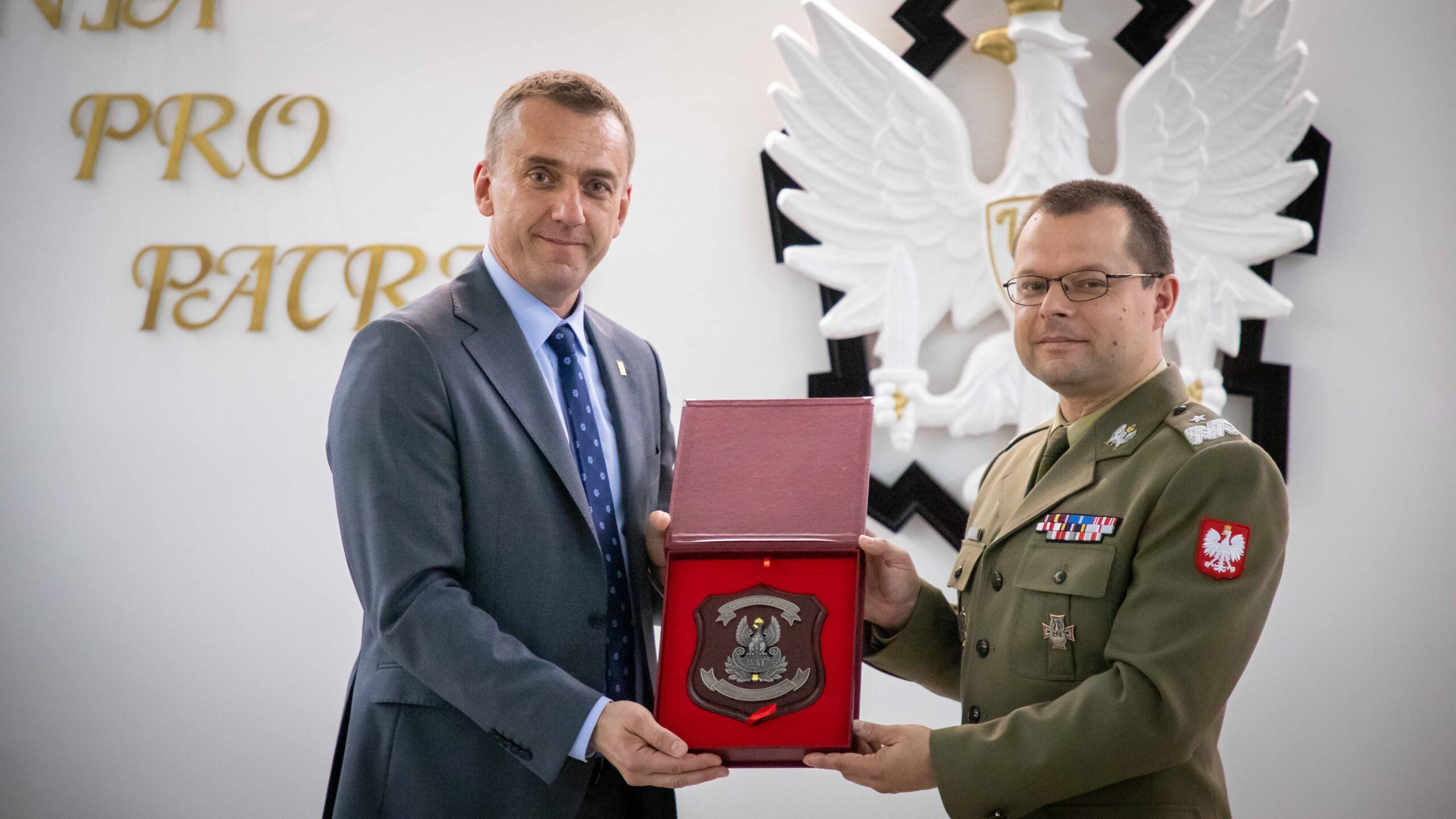 Rektor Politechniki Krakowskiej profesor Andrzej Szarata i Rektor-Komendant WAT generał bryg. profesor Przemysław Wachulak trzymają pudełko z herbem.