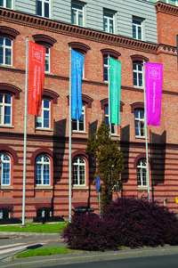 Fragment głównego budynku PK z flagami wydziałów