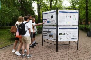 Grupa studentów zapoznaje się z treścią studenckiego plakatu 