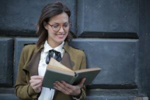 Uśmiechnięta dorosła kobieta czytająca książkę