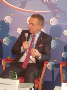 Rektor zabiera głos podczas panelu dyskusyjnego. Trzyma w ręce mikrofon