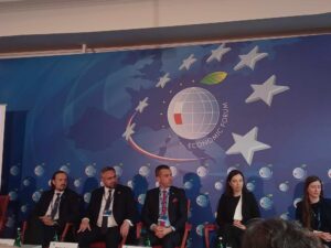 Uczestnicy panelu dyskusyjnego. Siedzą w fotelach, przed nimi stolik