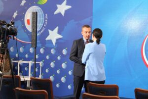 Rektor PK odpowiada na pytania dziennikarki. Stoją na tle baneru z logo Forum