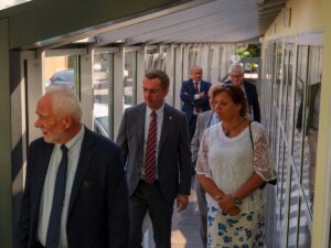 Osoby przemieszczają się wzdłuż korytarza, na pierwszym planie dyrektor Henryk Kultys, za nim rektor Andrzej Szarata i prof. Agnieszka Generowicz