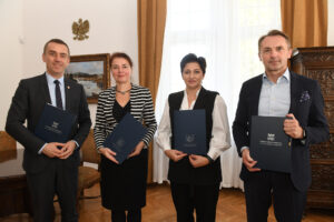 Do zdjęcia na stojąco pozują, od lewej: prof. Andrzej Szarata, prof. Lucyna Domagała, Aneta Andruszkiewicz, dyrektor HR w Unibep SA oraz Dariusz Blocher