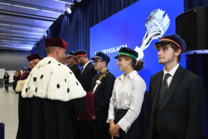 Immatrykulacja, rektor kładzie berło na ramieniu studenta