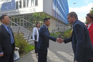 Przed budynkiem Wydziału Inżynierii i Technologii Chemicznej, prof. Bai Haili podaje rękę dziekanowi Piotrowi Michorczykowi