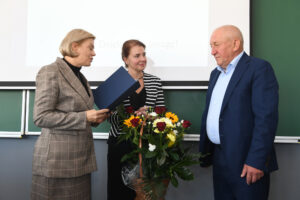 Dwie kobiety wręczają bukiet kwiatów Ryszardowi Florkowi