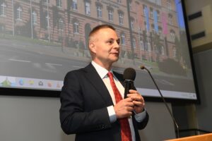 Prorektor Marek Bauer przemawia, trzyma mikrofon w ręce