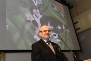 Dr Jacek Wojs z wykładem inauguracyjnym, w tle slajd jego prezentacji