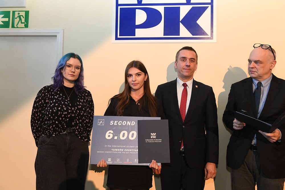 Zdobywczyni II nagrody pozuje do zdjęcia z rektorem PK i dwojgiem innych osób, w rękach trzyma symboliczny czek na 6 tys. zł