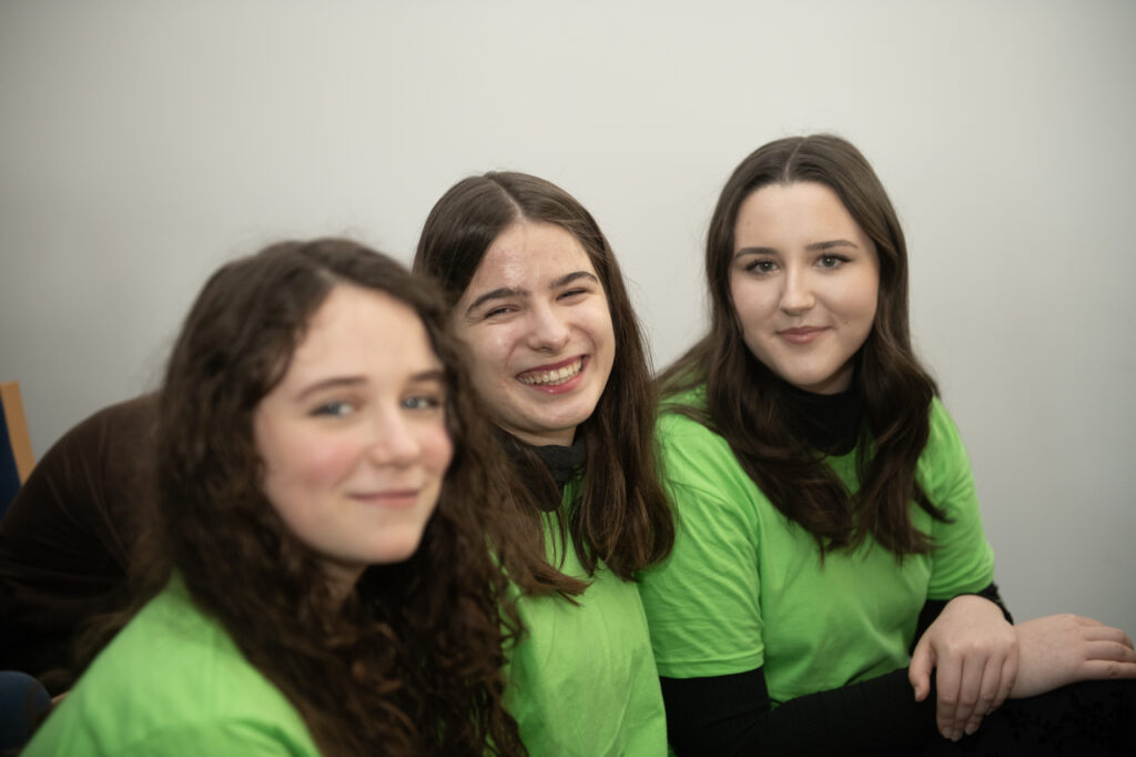 trzy studentki ubrane w intensywnie zielone koszulki