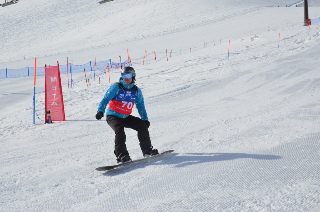 Snowboardzista zjeżdża na stoku i mija napis meta