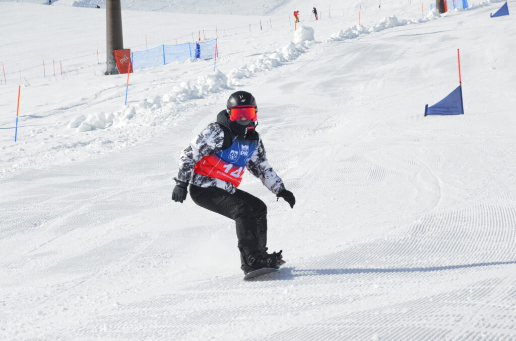 Snowboardzista zjeżdża po stoku.