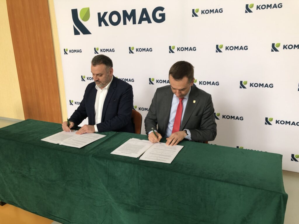 Dyrektor Instytutu Techniki Górniczej KOMAG dr hab. inż. Dariusz Prostański, prof. ITG KOMAG oraz rektor PK prof. dr hab. inż. Andrzej Szarata podpisują porozumienie o współpracy. Panowie siedzą przy stole przykrytym zielonym suknem