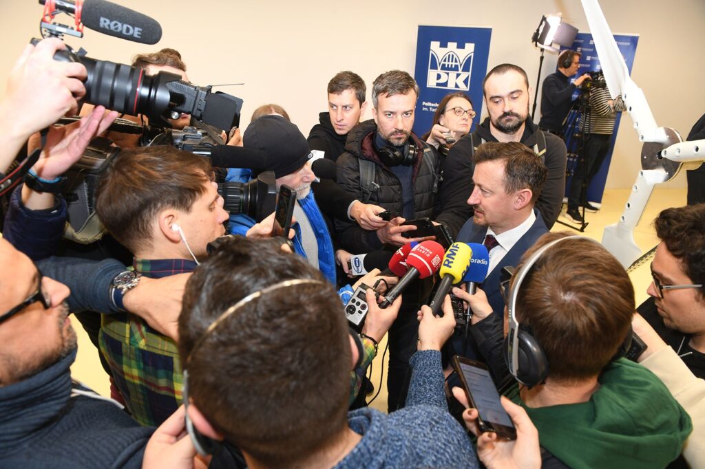 Konferencja prasowa z udziałem Adama Małysza. Wokół prezesa tłum dziennikarzy z mikrofonami