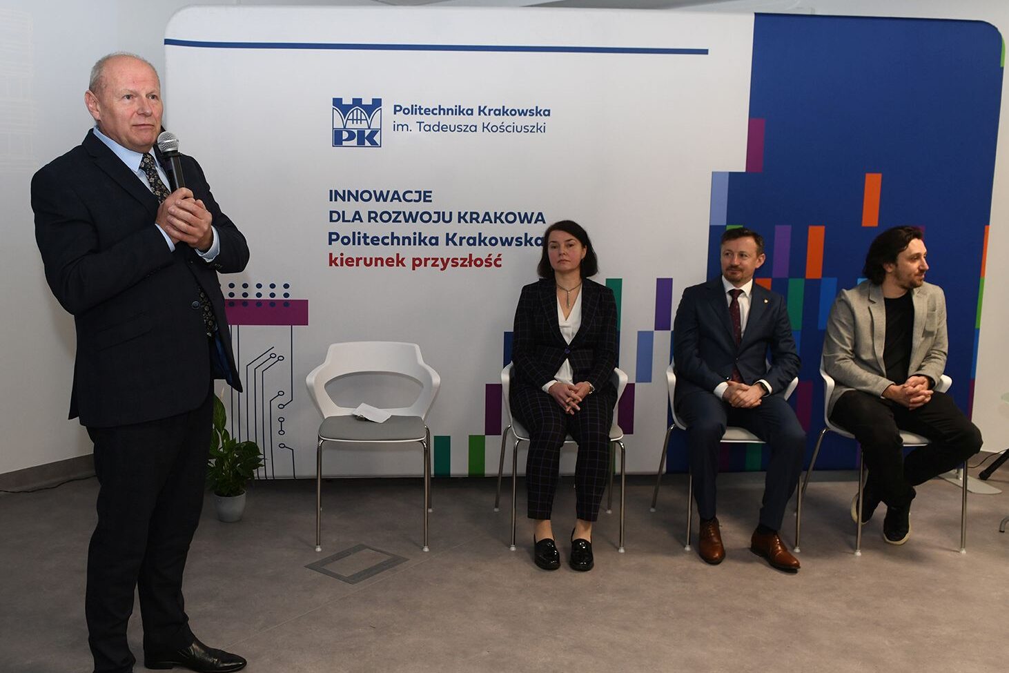 Na stojąco przemawia prorektor Tomasz Kapecki, siedzą dziekan Domagała, Adam Małysz i Jan Winkiel. W tle ścianka promocyjna z hasłem: Innowacje dla Rozwoju Krakowa - Politechnika Krakowska kierunek przyszłość
