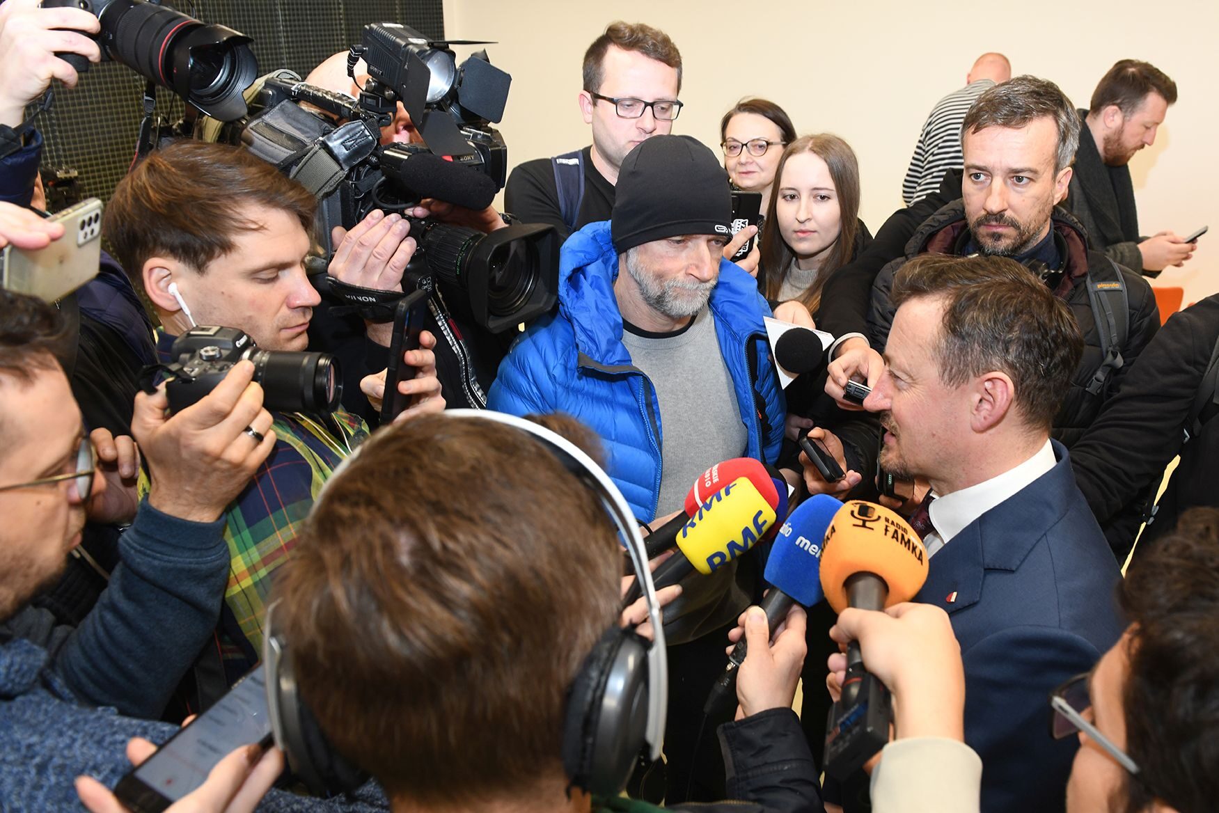 Konferencja prasowa z udziałem Adama Małysza. Wokół prezesa tłum dziennikarzy z mikrofonami